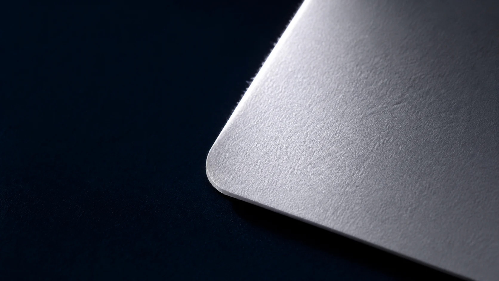 Blank card stock inspected under low-angle raking light